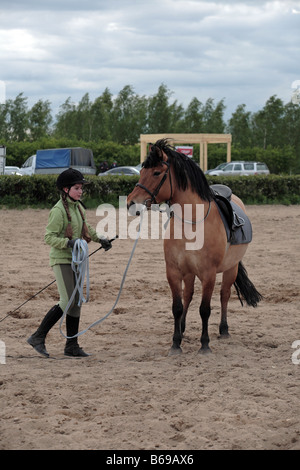 Ten year old girl preparing to ride a horse in an equestrian event Stock Photo