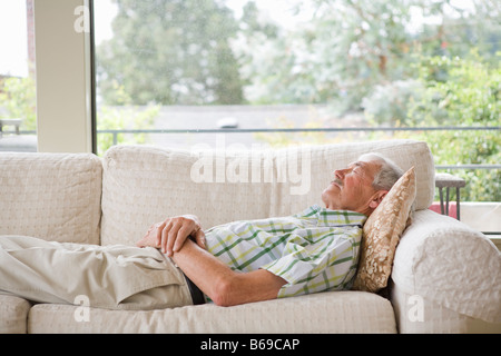 Man napping on a couch Stock Photo