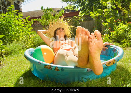 Woman lying in a wading pool Stock Photo