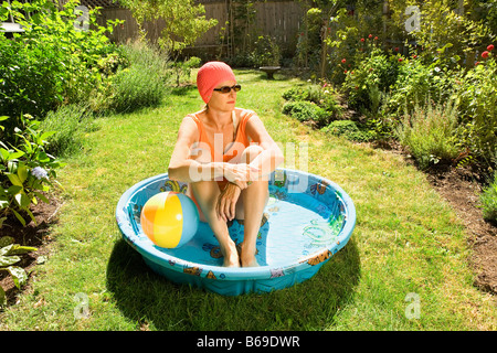 Woman sitting in a wading pool Stock Photo