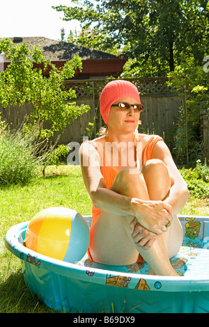 Woman sitting in a wading pool Stock Photo