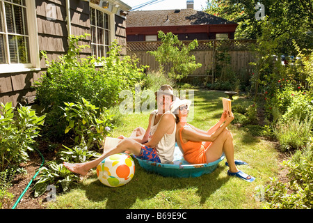 Couple holding books in a wading pool Stock Photo