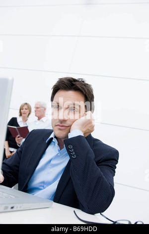 Man bored sitting at table Stock Photo