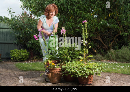 Mature woman watering plants Stock Photo