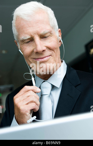 Older man listening wearing head phones Stock Photo