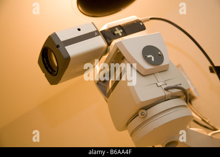 security surveillance video camera on swivel base with power cord coming out of the top. Angled view Stock Photo