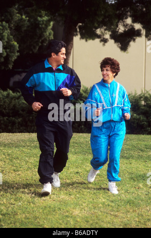 Hispanic couple in exercise clothing jog in park. Stock Photo