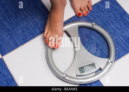 Woman stepping onto scales, low section Stock Photo