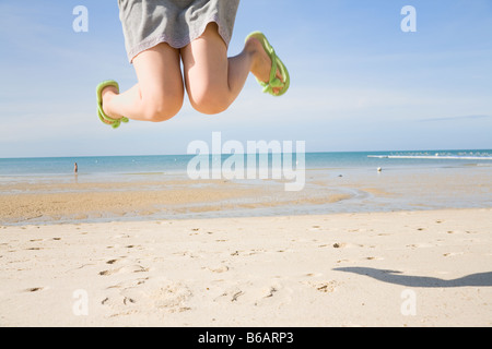 Legs of young woman jumping at beach Stock Photo