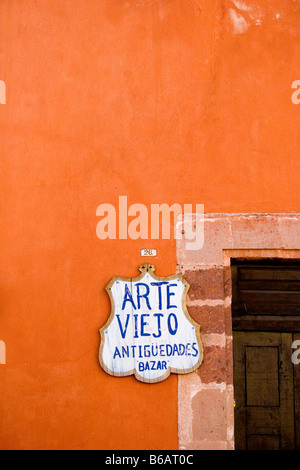 Sign advertising antiques next to door on colorful building in San Miguel de Allende, Mexico Stock Photo