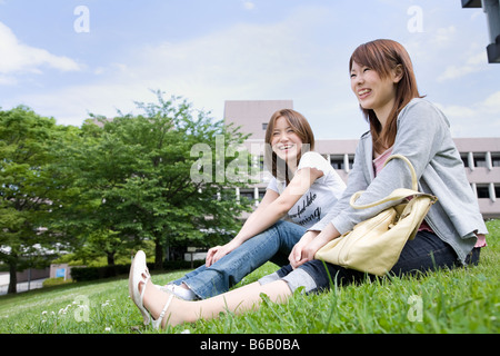 Young women sitting on lawn Stock Photo
