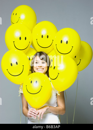 woman with smiley face balloons Stock Photo