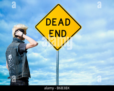 man looking at a dead end sign Stock Photo