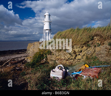 The lighthouse at Black Nore overlooking the Bristol Channel and Severn Estuary with discarded rubbish in the foreground. Portishead, Somerset, England. Stock Photo