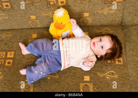 Lying baby with plushy animal 4 months Stock Photo