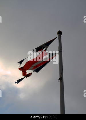 Union flag badly torn and damaged by the wind Stock Photo