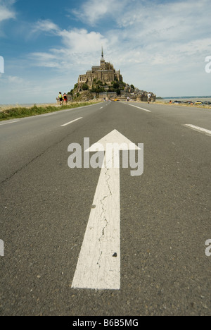 Arrow painted on the road on the approach to Mont Saint Michel. St Michaels Mount is a rocky tidal island in Normandy France Stock Photo