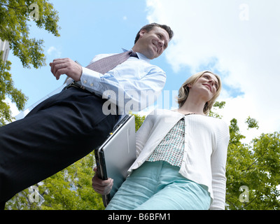 Low angle view of businessman and businesswoman smiling Stock Photo