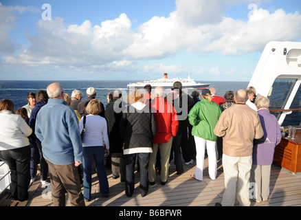 QE2 mid Atlantic on her 806th and final transatlantic voyage, crowds wave from the deck of the Queen Mary 2, tandem crossing Stock Photo