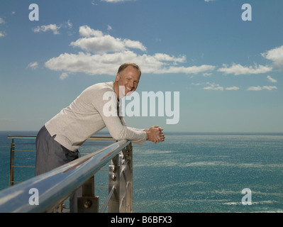 Portrait of man leaning on railing and smiling Stock Photo