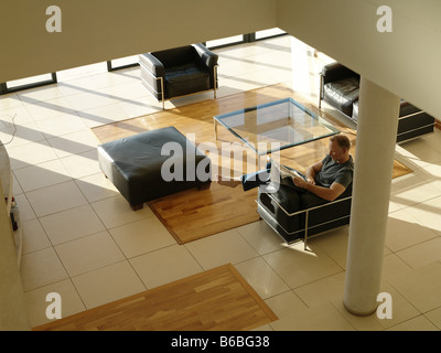 High angle view of man reading newspaper in armchair Stock Photo