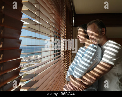 Side profile of couple romancing near window Stock Photo
