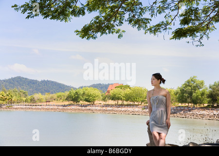 Young woman sitting at beach Stock Photo