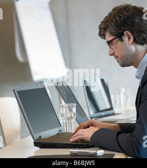 Side profile of businessman using laptop in office Stock Photo