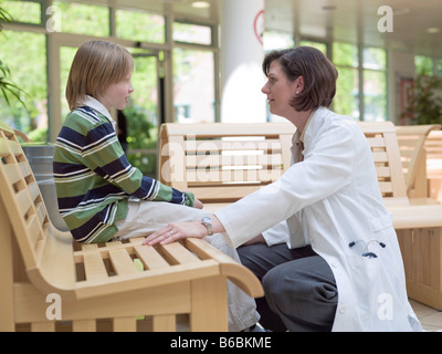 Female doctor talking with patient in waiting room Stock Photo