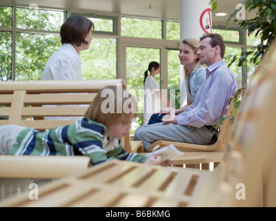 Couple consulting with female doctor at waiting area Stock Photo