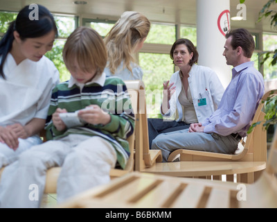 Couple consulting with female doctor at waiting area Stock Photo