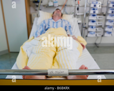 Man lying in hospital bed Stock Photo
