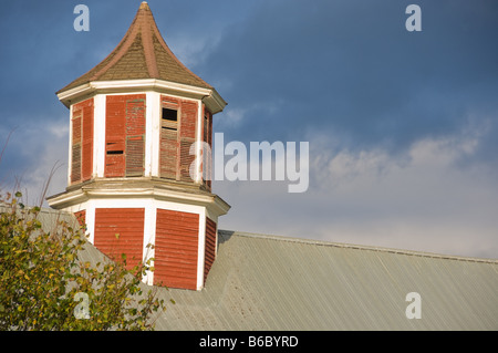 Old red cupola on a barn beneath a stormy sky Stock Photo