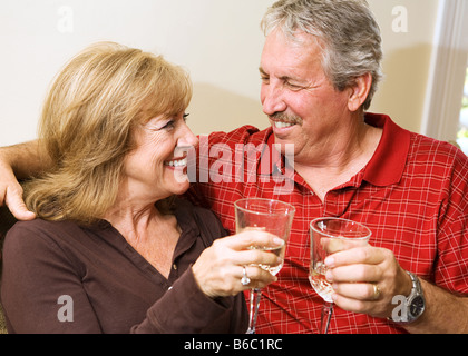 Beautiful mature couple enjoying a glass of wine and gazing into each others eyes Stock Photo