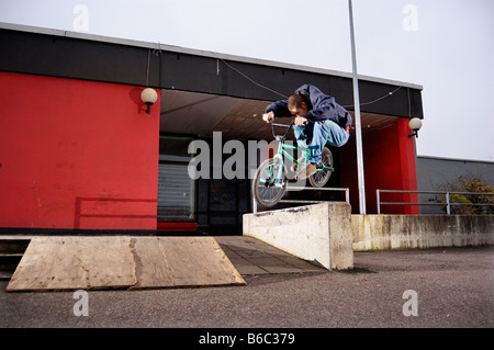 BMX'er jumps over the fence Stock Photo