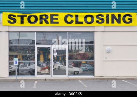 Store Closing Banner across storefront of empty retail store. USA Stock Photo