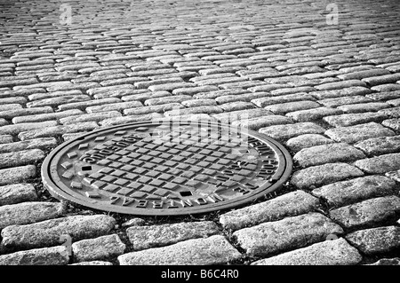 Cobble stones with maintenace cover in Montreal, Quebec, Canada. Stock Photo