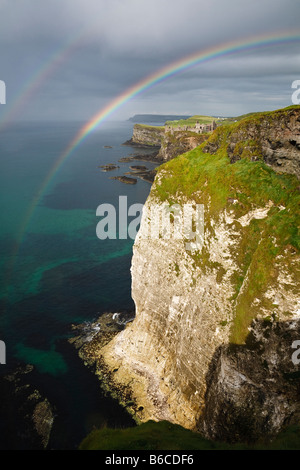 A double rainbow over the cliffs at White Rocks and view towards Dunluce Castle on the North Antrim coast, Northern Ireland Stock Photo