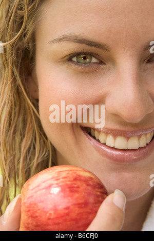 Portrait of woman holding apple and smiling Stock Photo