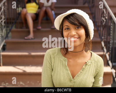 Smiling Hispanic woman with family in background Stock Photo