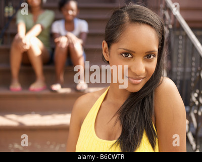 Smiling African woman with family in background Stock Photo