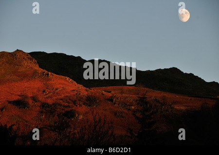 moon over lord grag above grasmere lake district cumbria winter country walks hills peaks tourism holiday fields sheep stone dry Stock Photo