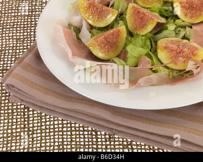 Fresh Ripe Fig And Italian Prosciutto Ham Salad With Lettuce And Green Salad Leaves Served In A White Bowl With No People Stock Photo