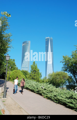 Young couple walking in the park near Tower Espacio and Tower Cristal. Madrid. Spain. Stock Photo