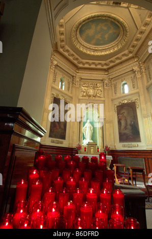 Votive candles and a statue of christ in the Notre Dame cathedral in Quebec City Stock Photo