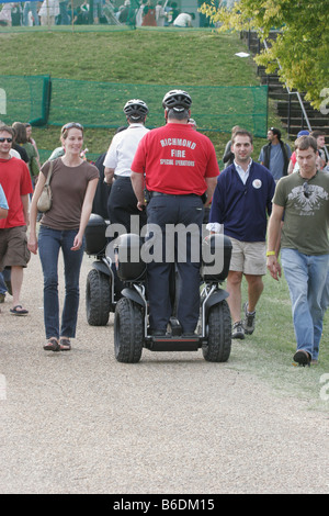 Fire and emergency services personnel utilizing a Segway personal transporter to patrol a large crowd at Richmond Folk Festival Stock Photo