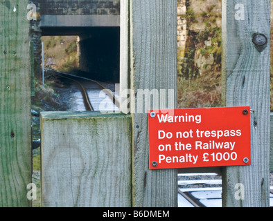 Railway line with warning signs to pedestrians not to venture onto the line. Stock Photo