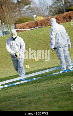 Forensics. Scene of crime officers (SOCOs) positioning photo evidence markers around a crime scene. Stock Photo