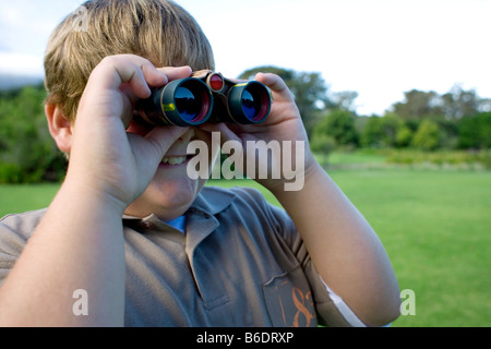 Boy using binoculars in a park. Stock Photo
