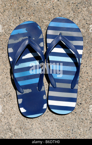 Still Life Color Photograph of a Pair of Worn Out Blue Striped Flip Flip Sandals Viewed from Above on a Sunny Day Copy Space Stock Photo